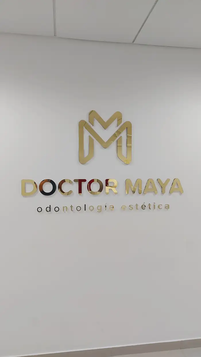 Letras y logotipo en acrílico espejo dorado del consultorio Doctor Maya sobre pared interior