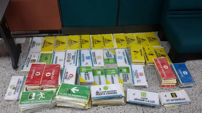 Lote de señales de seguridad terminadas antes del despacho: salida de emergencia, extintor, gabinete de incendios, kit antiderrame y avisos de riesgo